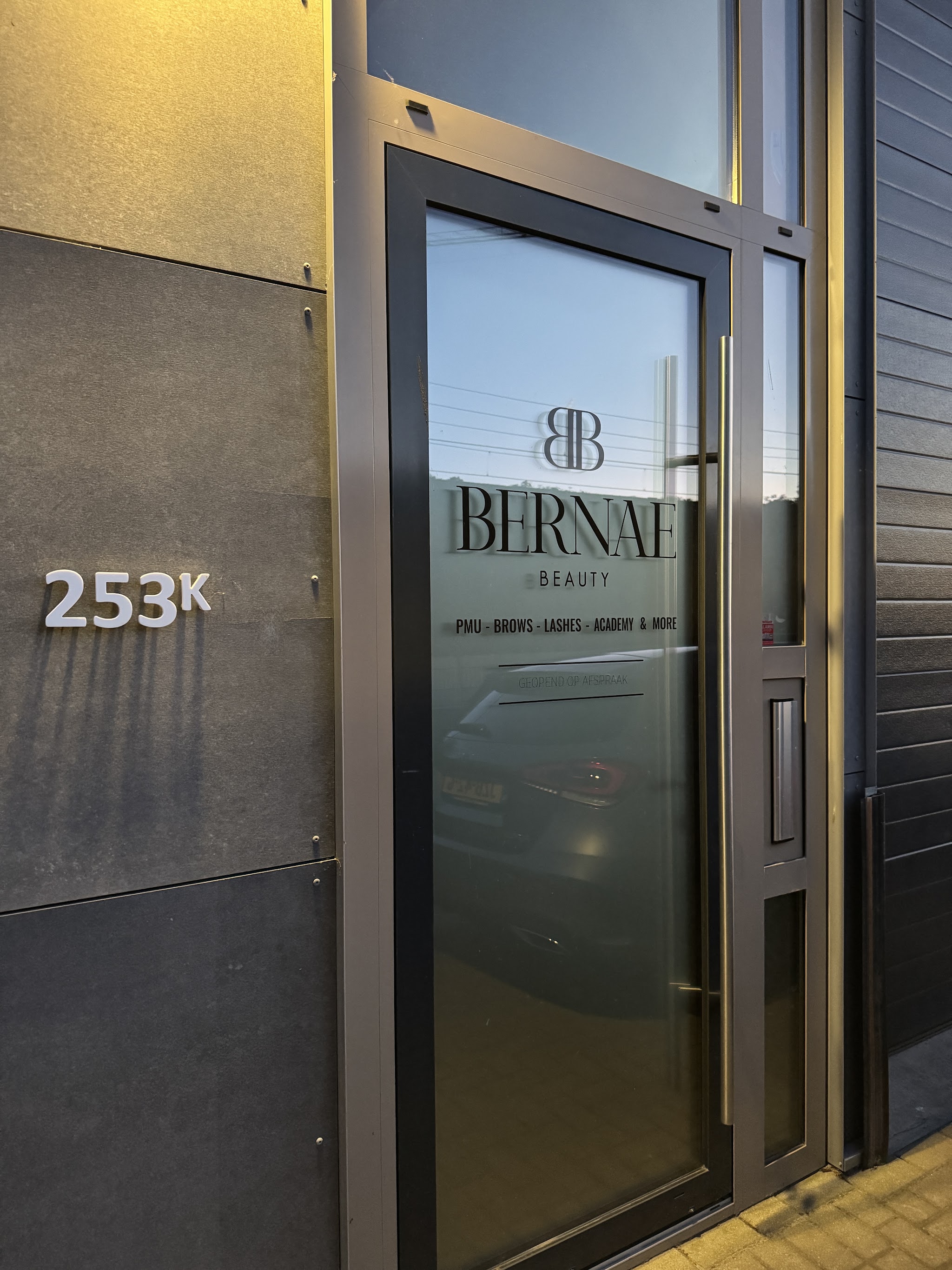 De ingang van de salon, unit 253K, met het logo op het raam
